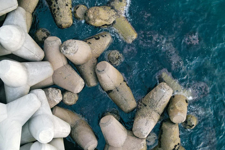 Concrete breakwater units along the edge of the sea